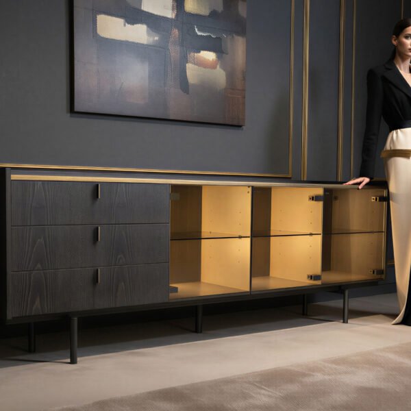 Ebonised ash sideboard with gold LED lighting in a dark styled interior with a woman standing beside it