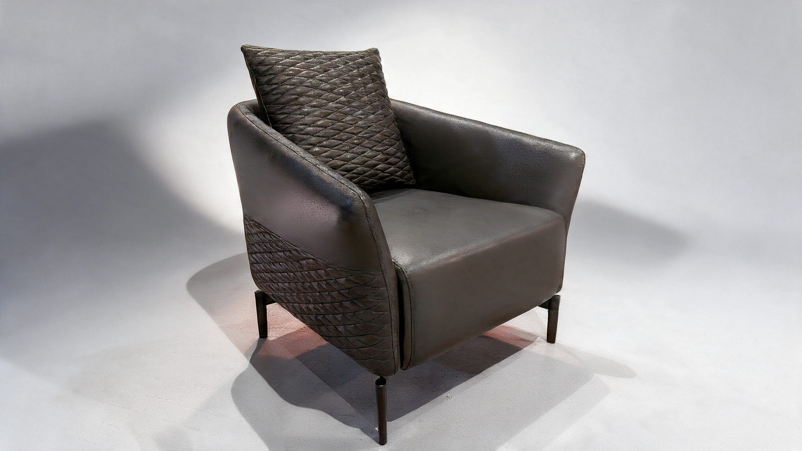 Black faux leather armchair with quilted cushion