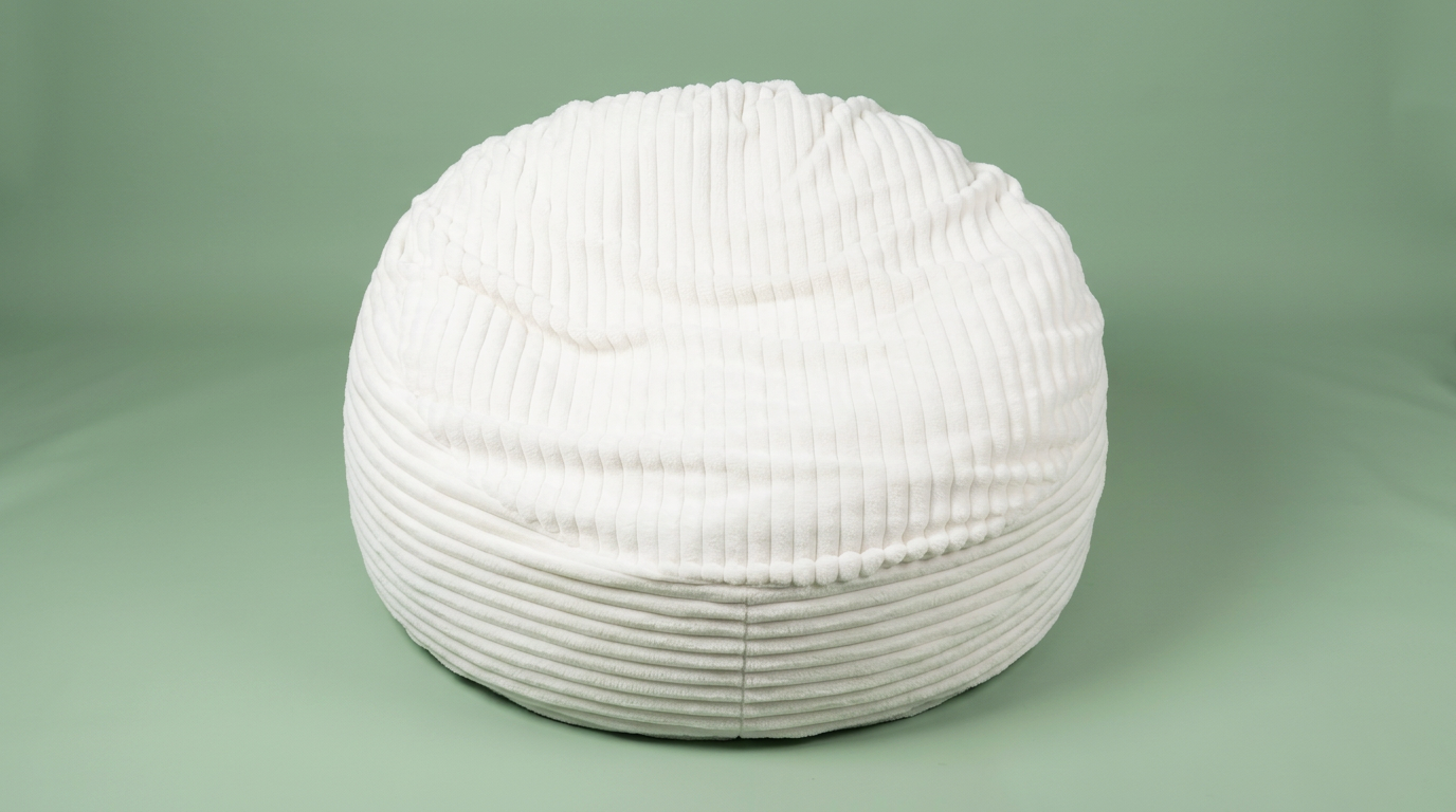 Cream ribbed faux fur bean bag on a sage green studio backdrop