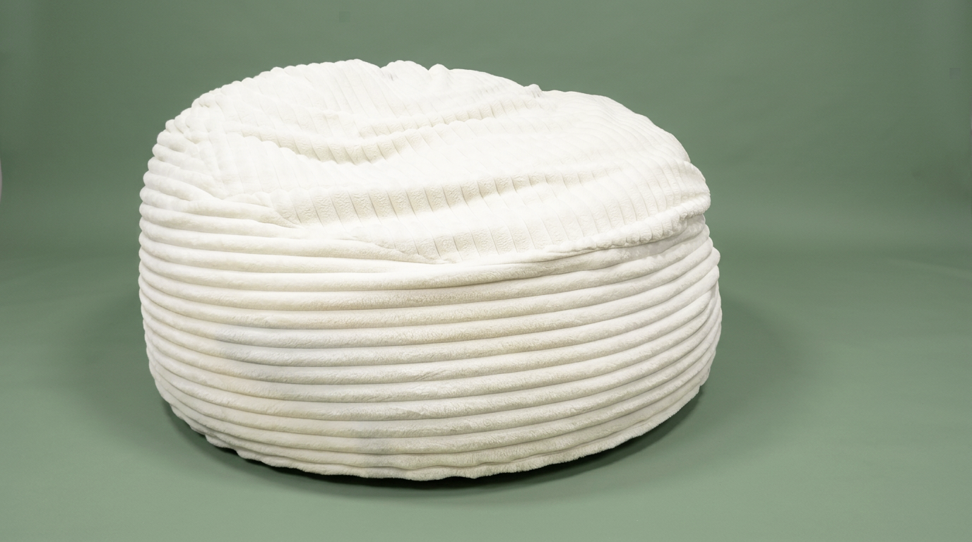 Cream ribbed faux fur bean bag on a sage green studio backdrop
