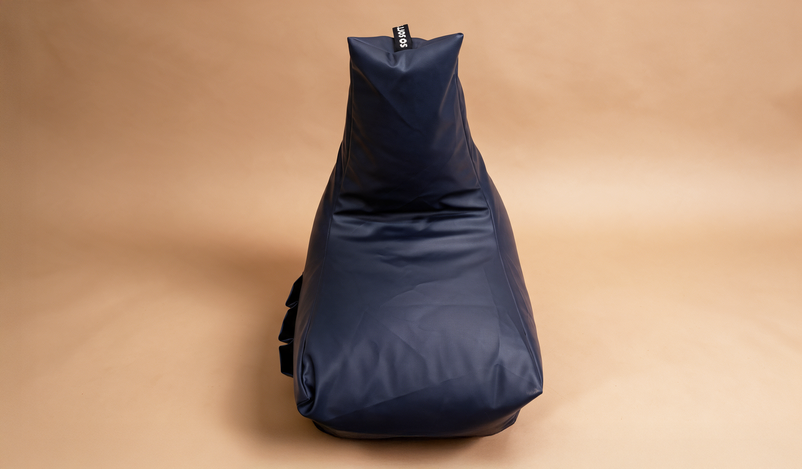 Navy bean bag lounger chair on a warm camel backdrop